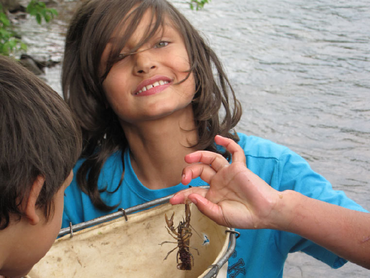 Child smiling with crayfish - Macroinvertebrate search turns up a female crayfish